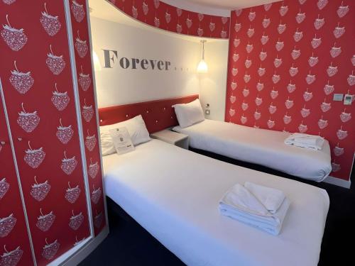 two beds in a room with red walls at Ibis Styles Liverpool Centre Dale Street - Cavern Quarter in Liverpool