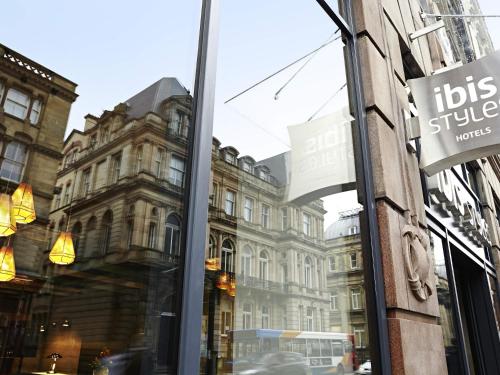 a reflection of a building in the window of a store at Ibis Styles Liverpool Centre Dale Street - Cavern Quarter in Liverpool