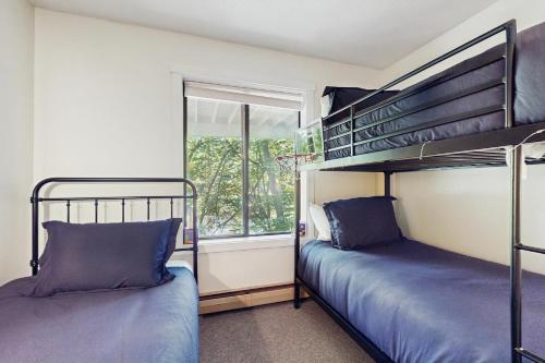 two bunk beds in a room with a window at Mill Run 3C in Quechee