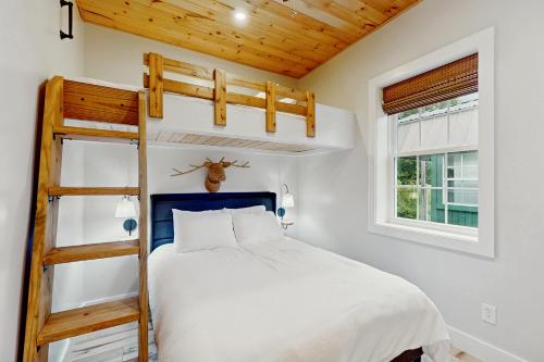 une chambre avec un lit superposé et une échelle dans l'établissement River Rock Cottage, à Boone