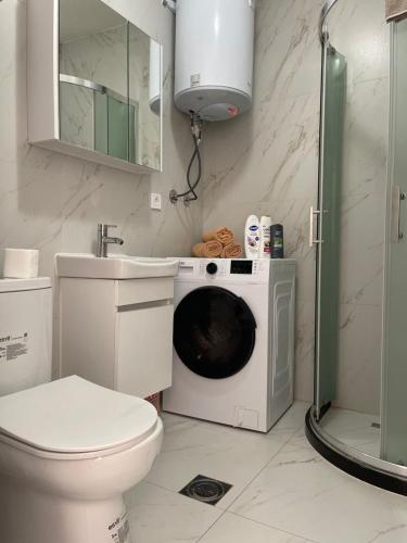 a bathroom with a washing machine and a sink at City View Prishtina in Pristina