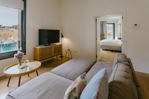 a living room with a couch and a tv at Cugo Gran Macina Malta in Senglea