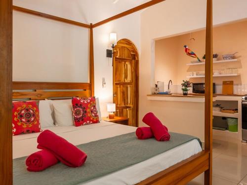 a bedroom with a large bed with red pillows at Casa Mapache in Tamarindo
