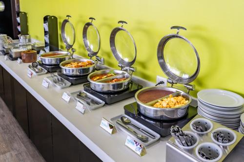 a buffet with many pots and pans of food at Holiday Inn Express & Suites Puebla Angelopolis by IHG in Puebla