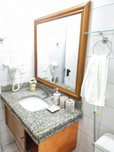 a bathroom with a sink and a mirror at Flat Mar Premium 1408 in Fortaleza