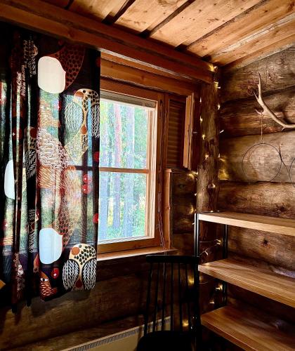 a window in a log cabin with a curtain at Lapland Lodge Pyhä Ski in, sauna, free WiFi, national park - Lapland Villas in Pyhätunturi