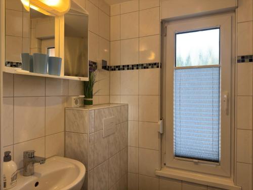 a white bathroom with a sink and a window at Hideaway Near Castle Views in Blankenburg