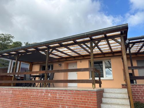a wooden pergola on the side of a house at Hideaway Near Castle Views in Blankenburg