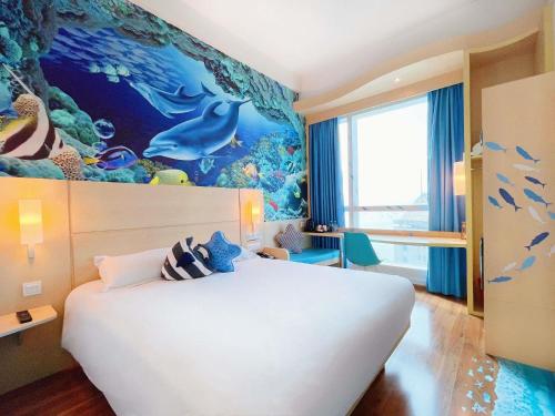 a bedroom with a large white bed with an underwater mural at Ibis Hong Kong Central & Sheung Wan in Hong Kong