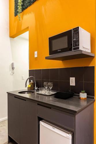 a kitchen with a sink and a microwave at ZEST Pedroso in Sao Paulo