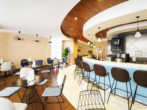 a restaurant with a bar and tables and chairs at Ibis Hong Kong Central & Sheung Wan in Hong Kong