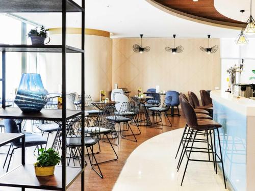 a restaurant with tables and chairs with butterflies on the wall at Ibis Hong Kong Central & Sheung Wan in Hong Kong
