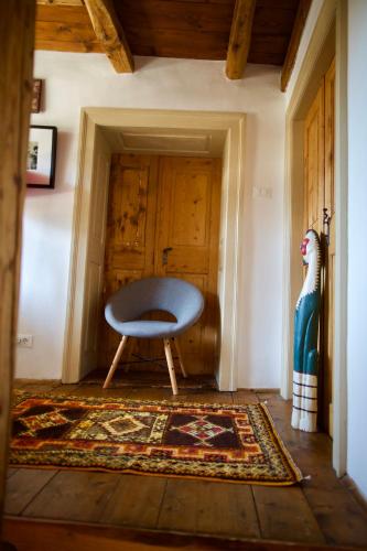 a blue chair in a room with a rug at Room for 2 - Pri B'zjak in Kobarid