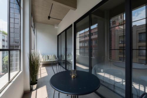 a balcony with a table and some windows at Zielo Rentals Palma ,Private balcony, Rooftop Walk to Zocalo in Mexico City