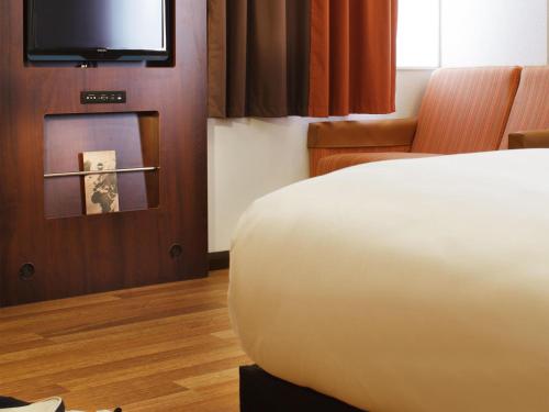 a hotel room with a bed and a television at ibis London Shepherds Bush - Hammersmith in London