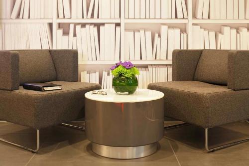 a lobby with two chairs and a vase of flowers on a table at ibis London Shepherds Bush - Hammersmith in London