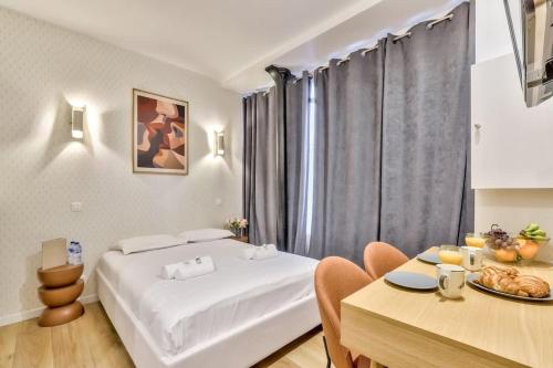 a hotel room with a bed and a table with a tableablish at Charmant studio au coeur des Batignolles in Paris