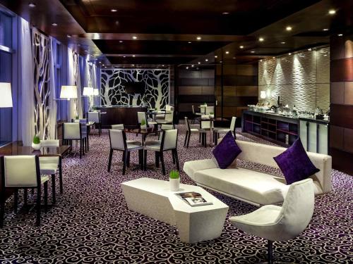 a lobby with couches and tables and a bar at Grand Mercure Danang in Da Nang