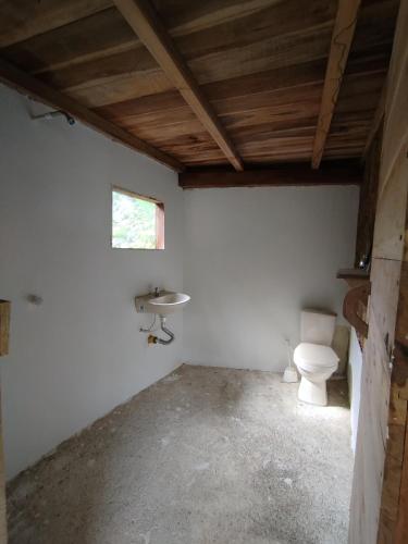 a bathroom with a toilet and a sink at Siwi Lodge in Cañaveral