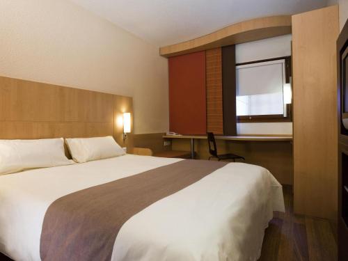 a bedroom with a large bed and a window at ibis Montes Claros Shopping in Montes Claros