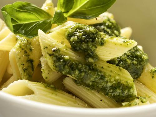 a bowl of broccoli and pasta with basil on top at ibis Montes Claros Shopping in Montes Claros