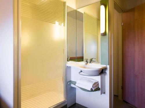 a bathroom with a sink and a mirror at Ibis Budget Sevilla Aeropuerto in Seville