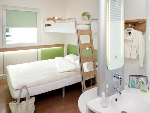 a small room with a bunk bed and a sink at Ibis budget Koeln Messe in Cologne