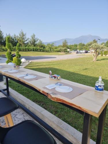 a wooden table with plates on it in a field at Olympus Pantheon Luxury Rooms in Plaka Litochorou