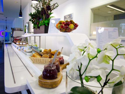 a bakery with a counter with pastries and flowers at Ibis budget Koeln Messe in Cologne