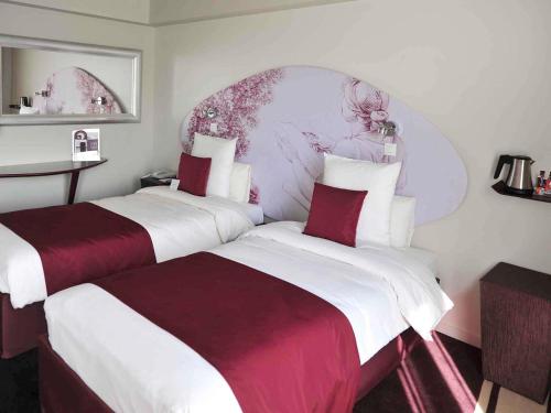 two beds sitting next to each other in a hotel room at Mercure Paris Bastille Marais in Paris