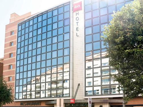 a large glass building with a sign on it at ibis Issy les Moulineaux "Val de Seine" in Issy-les-Moulineaux