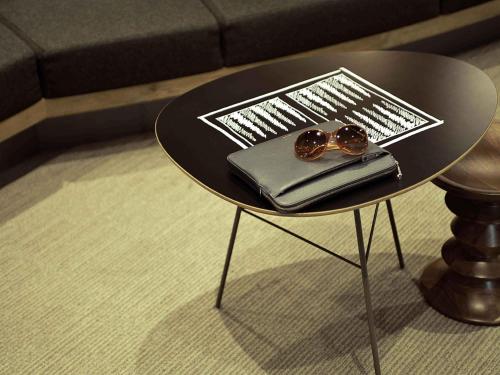 a small black table with a pair of glasses on it at ibis Issy les Moulineaux "Val de Seine" in Issy-les-Moulineaux