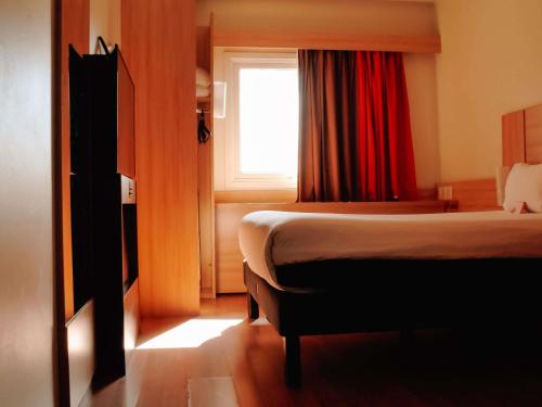 a hotel room with a bed and a window at ibis Santiago Providencia in Santiago