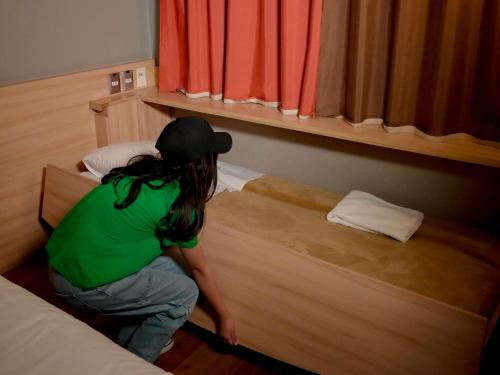 a person kneeling on a bed in a room at ibis Santiago Providencia in Santiago
