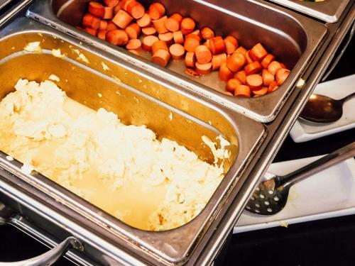 two trays of carrots and rice in a stove at ibis Santiago Providencia in Santiago