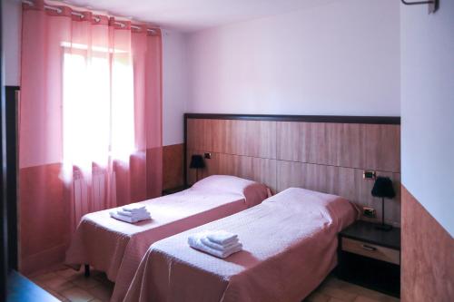 two beds in a hotel room with towels on them at Residenza Sant'Andrea in Campobasso