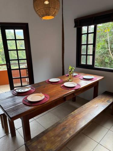 a wooden table with plates on it in a room at Casa Ilhabela vista Mar Perequê in Santos