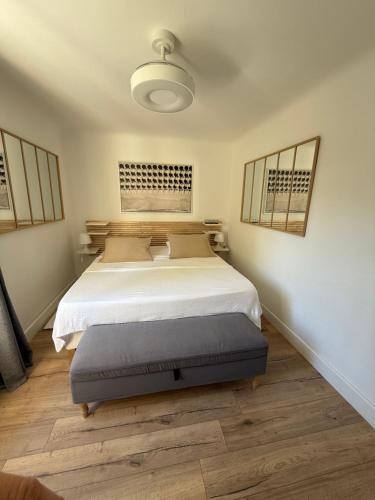 a bedroom with a large white bed with a blue ottoman at Lorette Hideway in Saint-Tropez