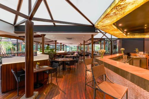 a restaurant with wooden floors and tables and chairs at Wyndham Sao Paulo Ibirapuera Convention Plaza in Sao Paulo