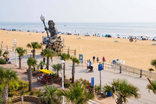 a view of a beach with a statue and the ocean at Four Sails Resort in Virginia Beach