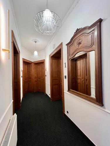 a hallway with wooden doors and a large mirror at Grand Apartments Piotrkowska No1 in Łódź