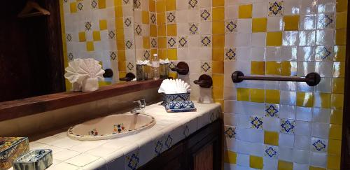 une salle de bain avec un lavabo et un miroir dans l'établissement Posada de las Flores Loreto, à Loreto