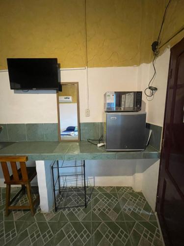 a counter with a microwave and a television on it at Casa Del Merman at GayMontanita House in Montañita
