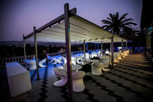 a row of white chairs on a roof at night at Villa Caribe Resort & Spa in Spigno Saturnia