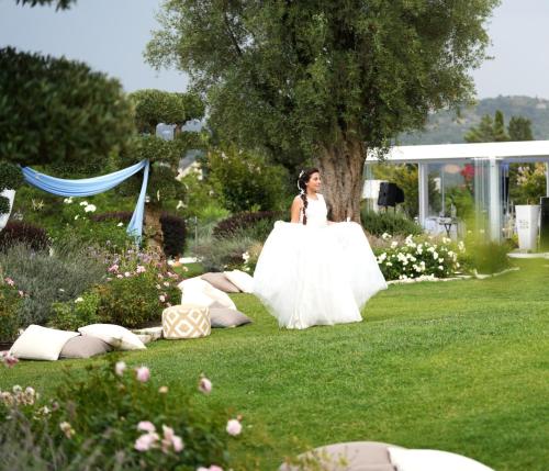 a woman in a white dress in a garden at Villa Caribe Resort & Spa in Spigno Saturnia