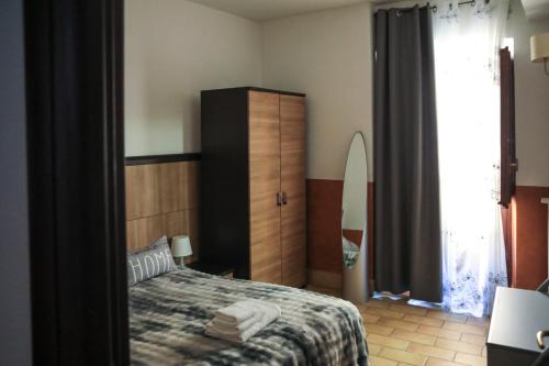 a bedroom with a bed and a dresser and a window at Residenza Sant'Andrea in Campobasso