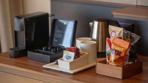 a desk with a computer monitor and snacks on it at Holiday Inn Algarve Albufeira by IHG in Albufeira