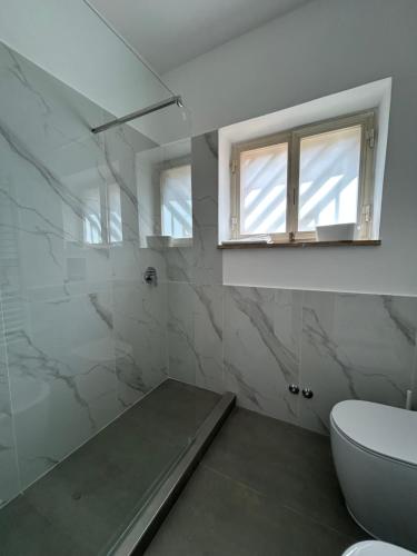a bathroom with a toilet and a window at Dimore di Baia in Bacoli