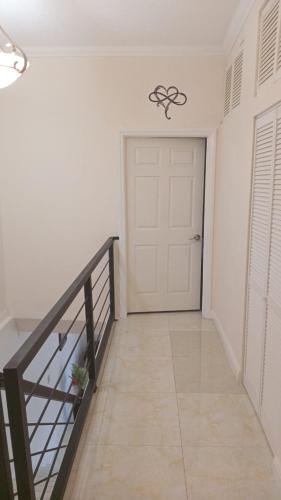 a hallway with a white door and a staircase at palmview estate townhouse in Mammee Bay