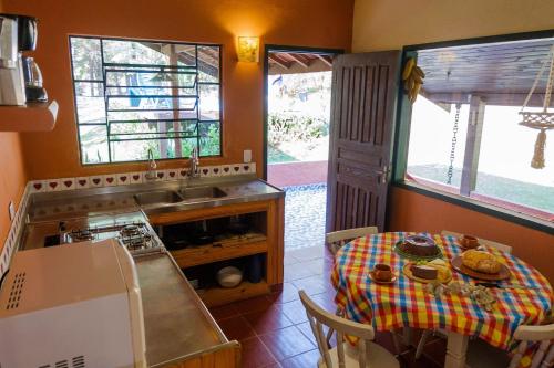 a kitchen with a table and a sink and a table and a table at Cabana Catuaí - com piscina privativa in Paiol Grande